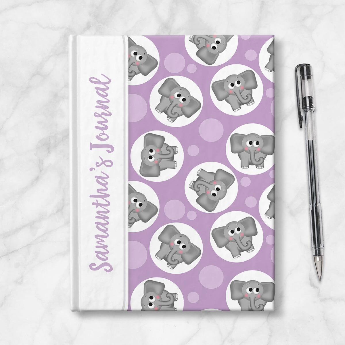 Personalized Cute Purple Elephant Journal at Artistically Invited. Image shows the book on a countertop next to a pen.