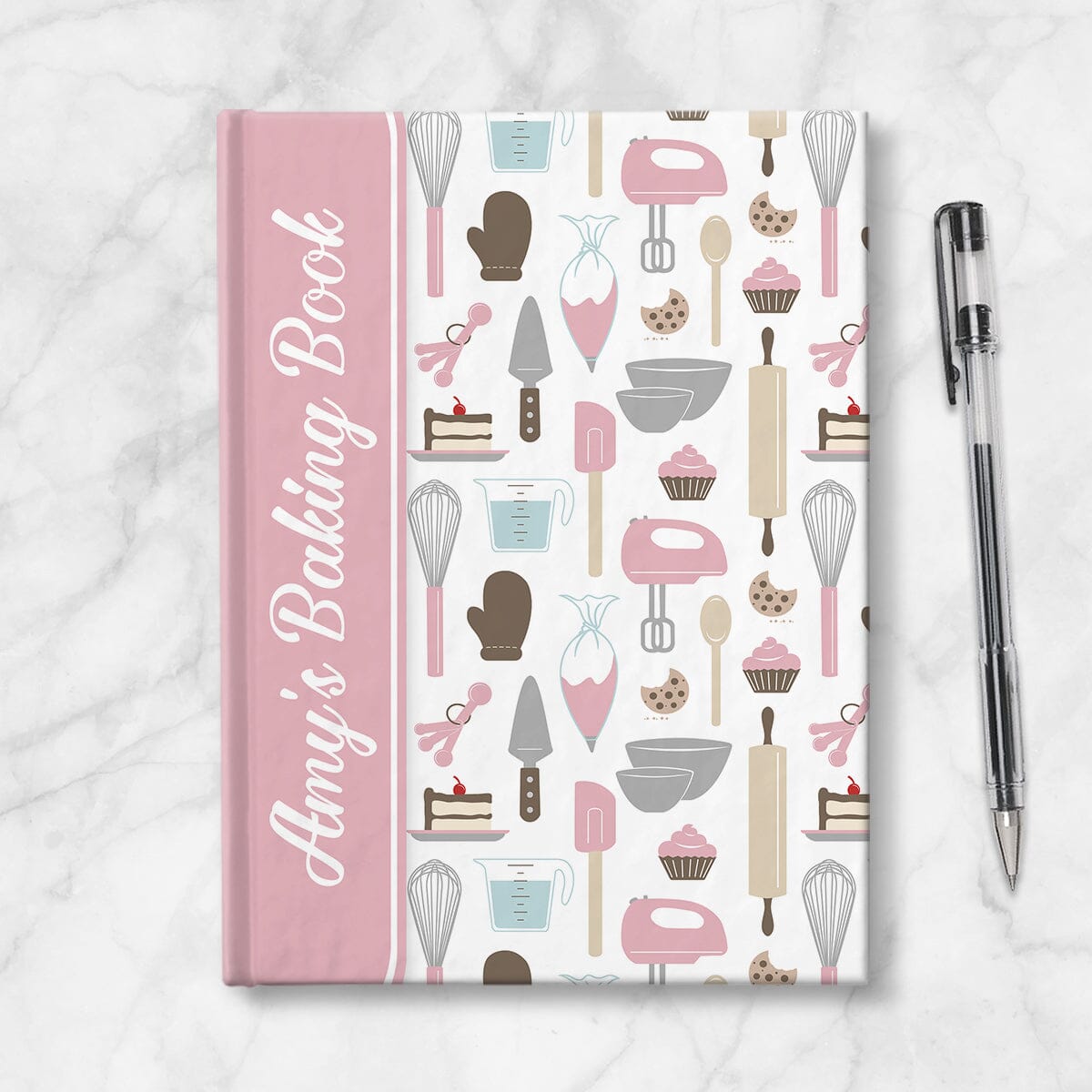 Personalized Pink Baking Pattern Journal at Artistically Invited. A journal or sketchbook with a pink binding illustration wrapping around the spine, over a pink baking pattern for the background. Your name or text of your choice is custom printed in a cute white script font on the front, sideways over the pink design near the spine. Image shows the book next to a pen.