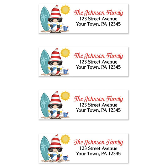 Summer Beach Gnome Address Labels at Artistically Invited. Sheet of 4 labels. These address labels are designed with an illustration of a cute gnome holding a beach ball with a surfboard and a bucket in the sand, and a sun above. Your personalized return address is custom printed in red and black over white to the right of the beach-themed gnome.