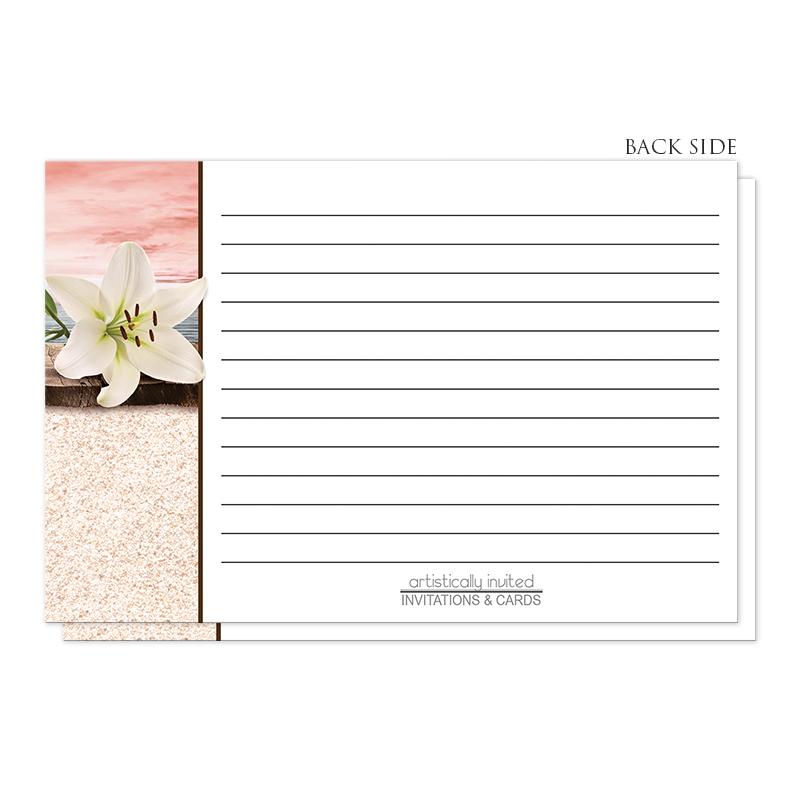 Lily Seashells and Sand Coral Beach Recipe Cards (back side) at Artistically Invited. Coral beach recipe cards designed with a white lily flower on a rustic wood dock with a coral sky behind it over a beige sand texture background illustration along the left side. The recipe on these coral beach recipe cards is to be handwritten over white on the remaining area of the recipe cards, with two watermark seashells beside the ingredients section.