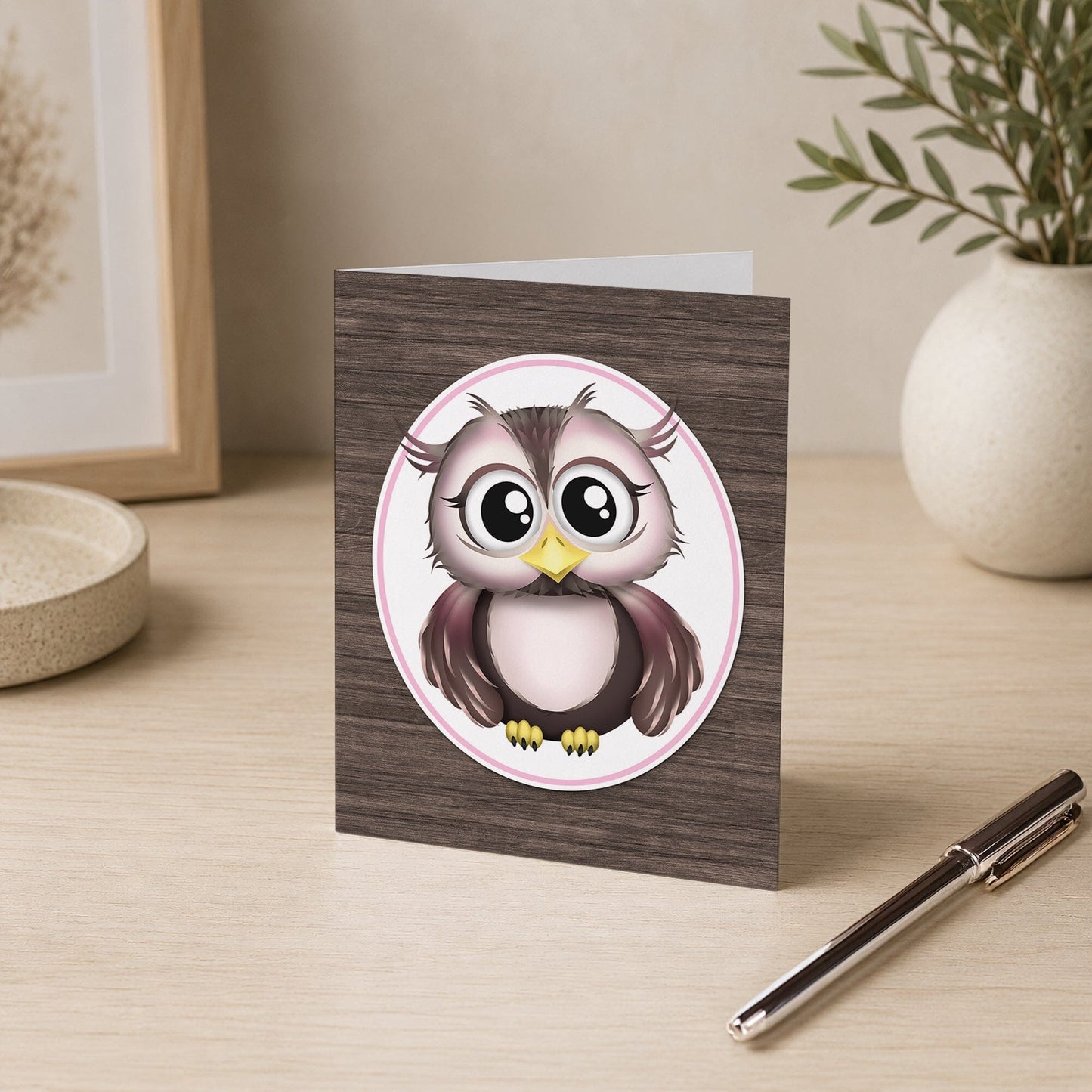 Adorable Owl Pink and Brown Note Card shown on a desk with a vase and a pen.