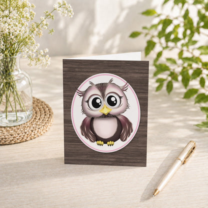 Adorable Owl Pink and Brown Note Card shown on a tabletop with a vase, spring and summer flowers, and a pen.