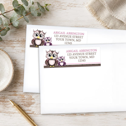 Adorable Pink Owl and Purple Baby Owl Address Labels, shown on white envelopes, on a wooden surface with eucalyptus leaves and a pen.