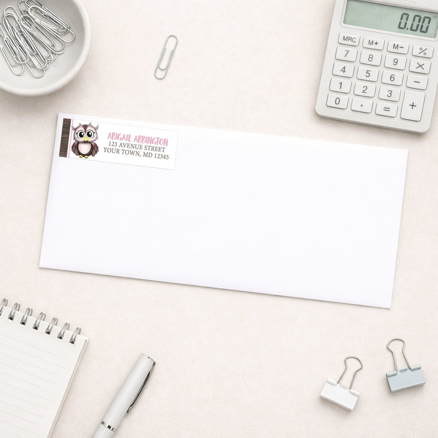 Adorable Pink and Brown Owl Address Label shown on a white envelope with everyday office supplies