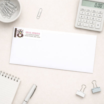 Adorable Pink and Brown Owl Address Label shown on a white envelope with everyday office supplies