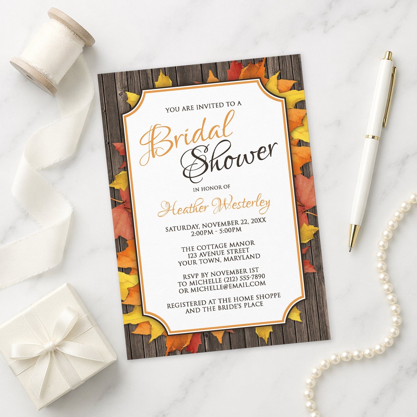 Autumn Orange White Wood Bridal Shower Invitation shown on a marble surface with a white gift box, pen, ribbon, and pearls.