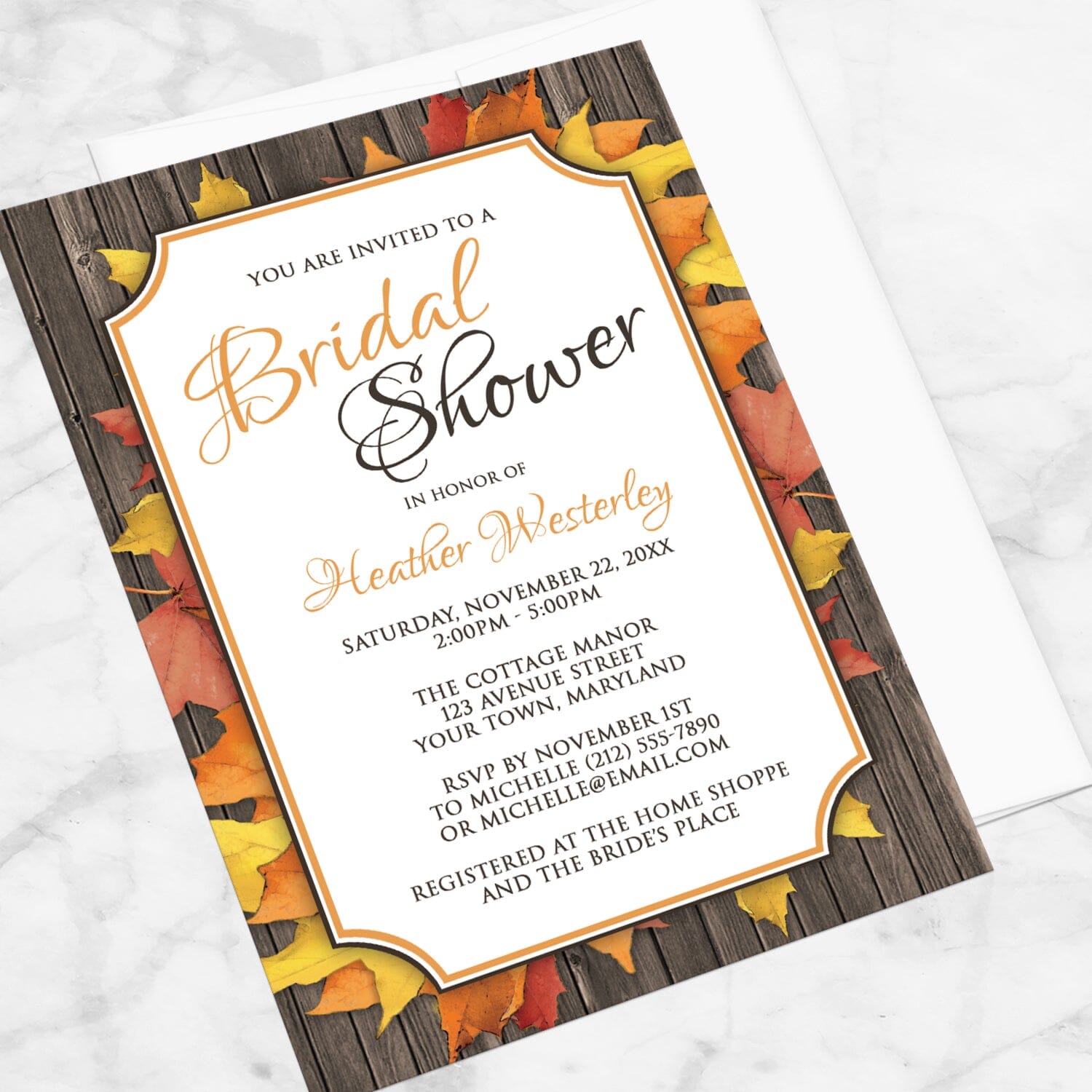 Autumn Orange White Wood Bridal Shower Invitation shown at an angle on a marble surface with a white envelope.