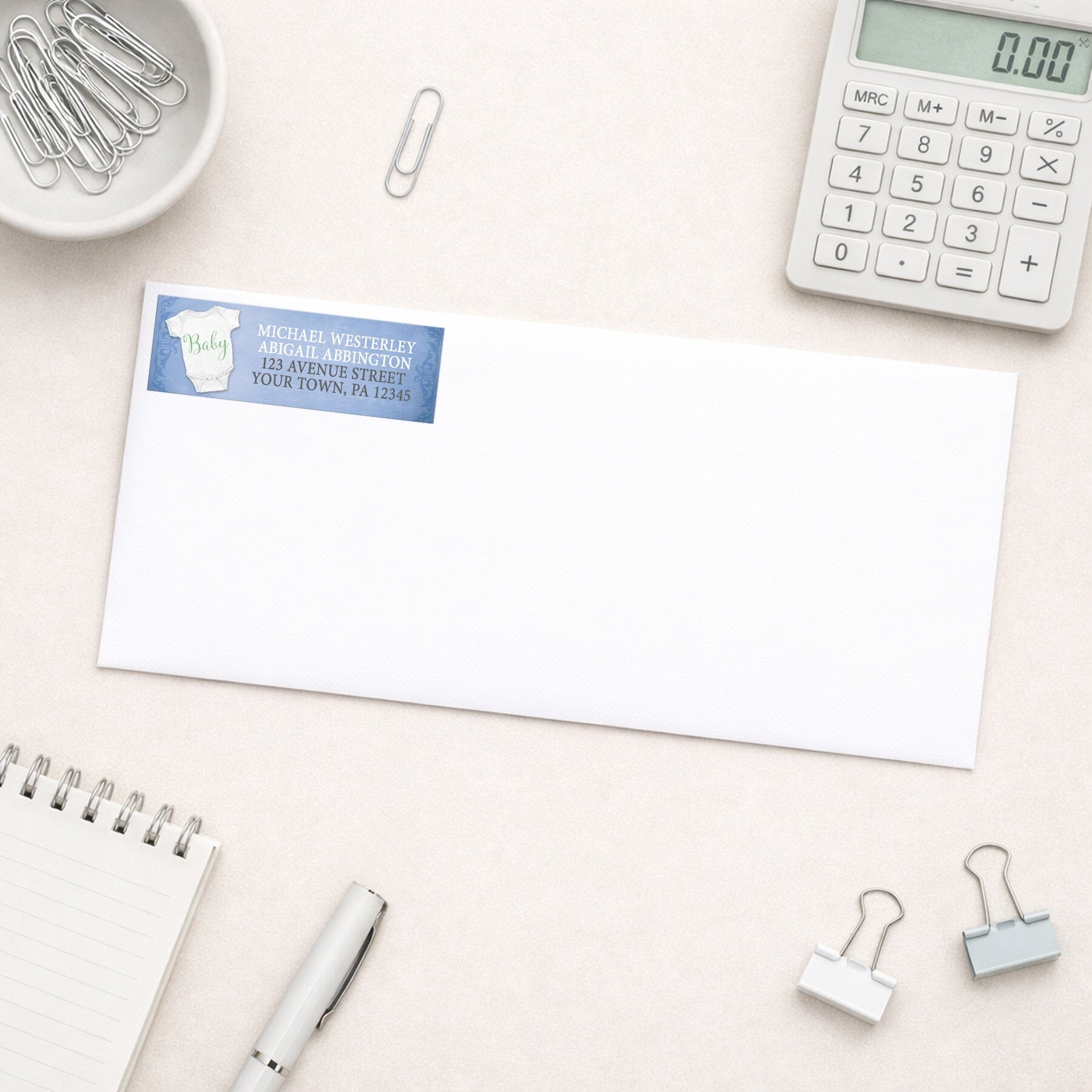 Baby Bodysuit on Blue Address Labels shown on a white envelope with office supplies