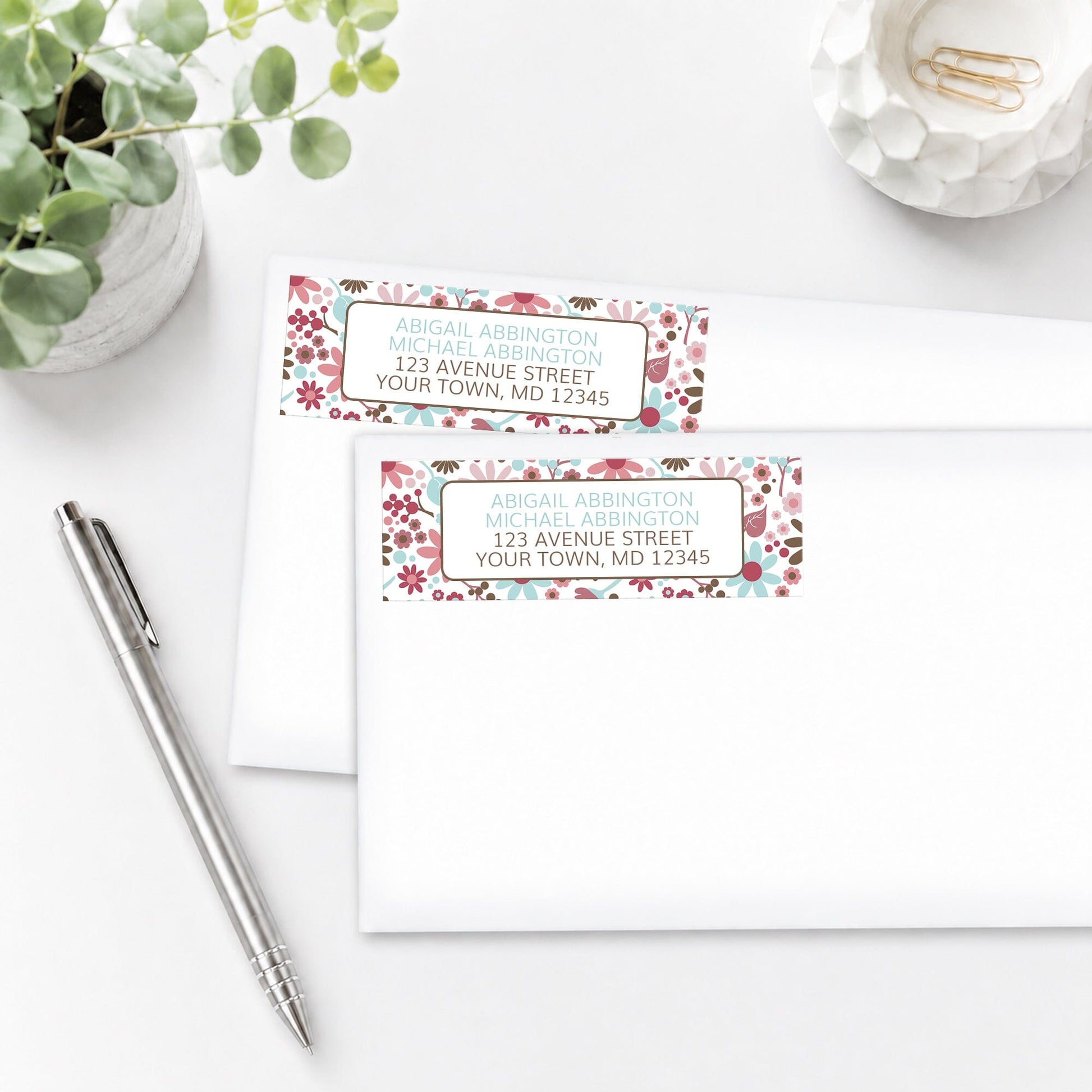 Berry Blue Summer Flowers Address Labels on white envelopes with a pen and plant on a white surface