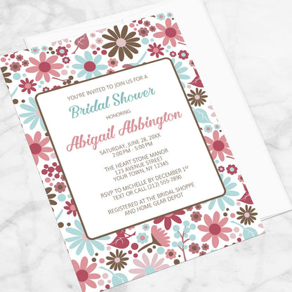 Berry Blue Summer Flowers Bridal Shower Invitation shown at an angle on a marble surface.