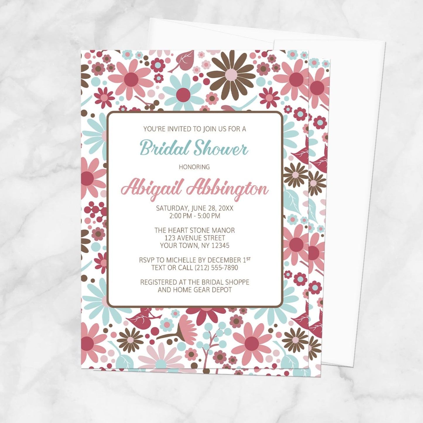 Bridal shower invitation with a pink, blue, and brown flowers design, shown on a marble surface