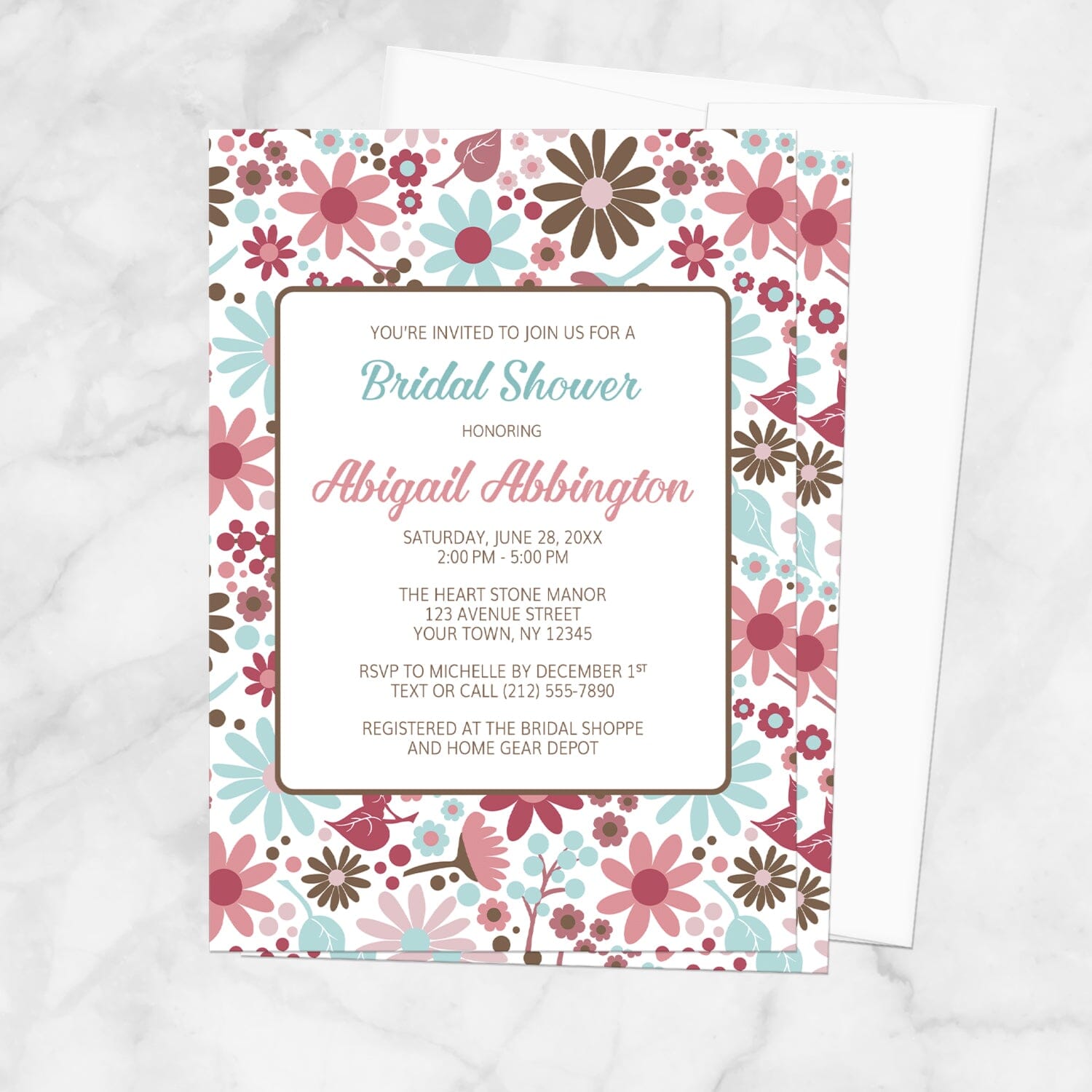 Bridal shower invitation with a pink, blue, and brown flowers design, shown on a marble surface