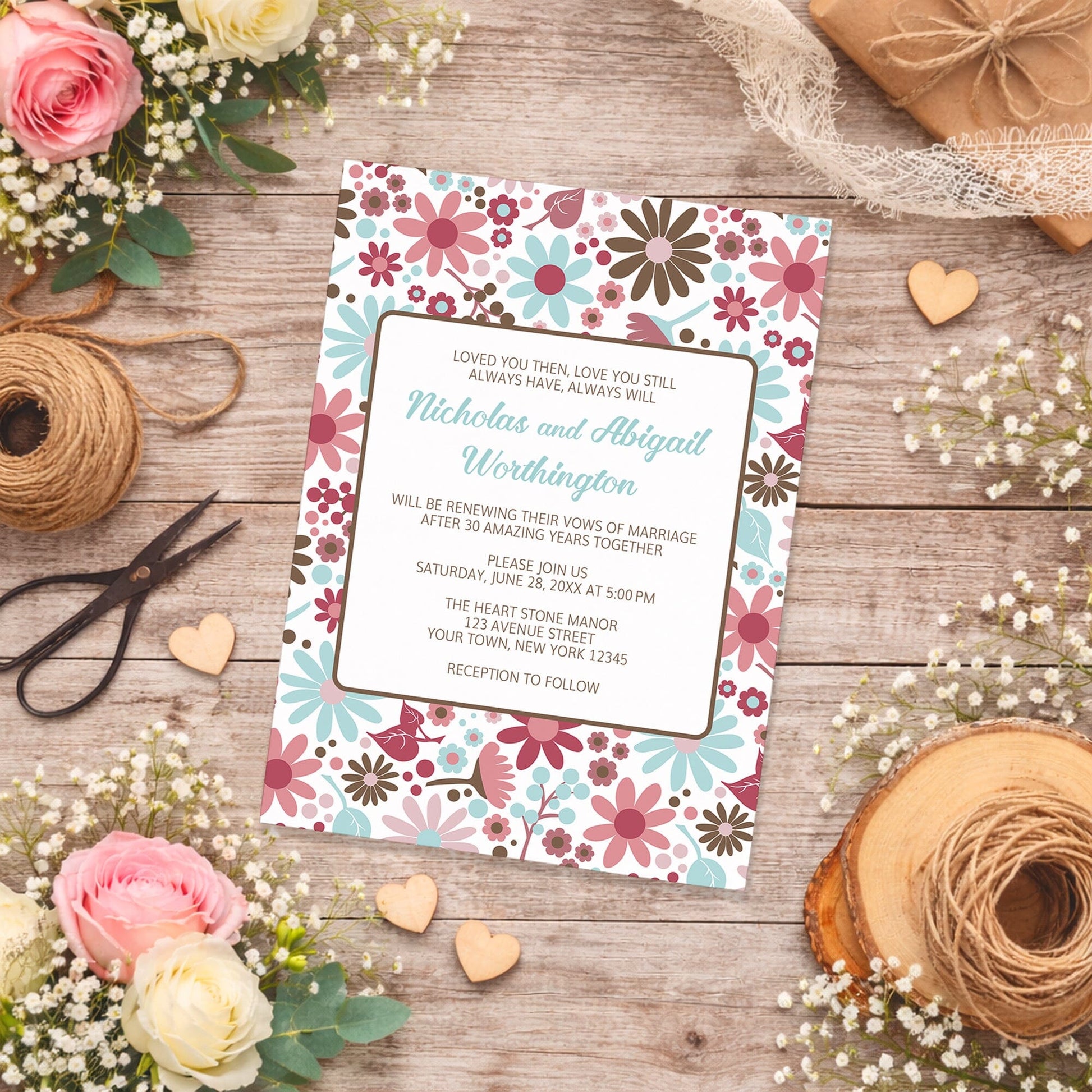 Berry Blue Summer Flowers Vow Renewal Invitation shown on a wooden surface with spring and summer flowers, small wood hearts, and twine.