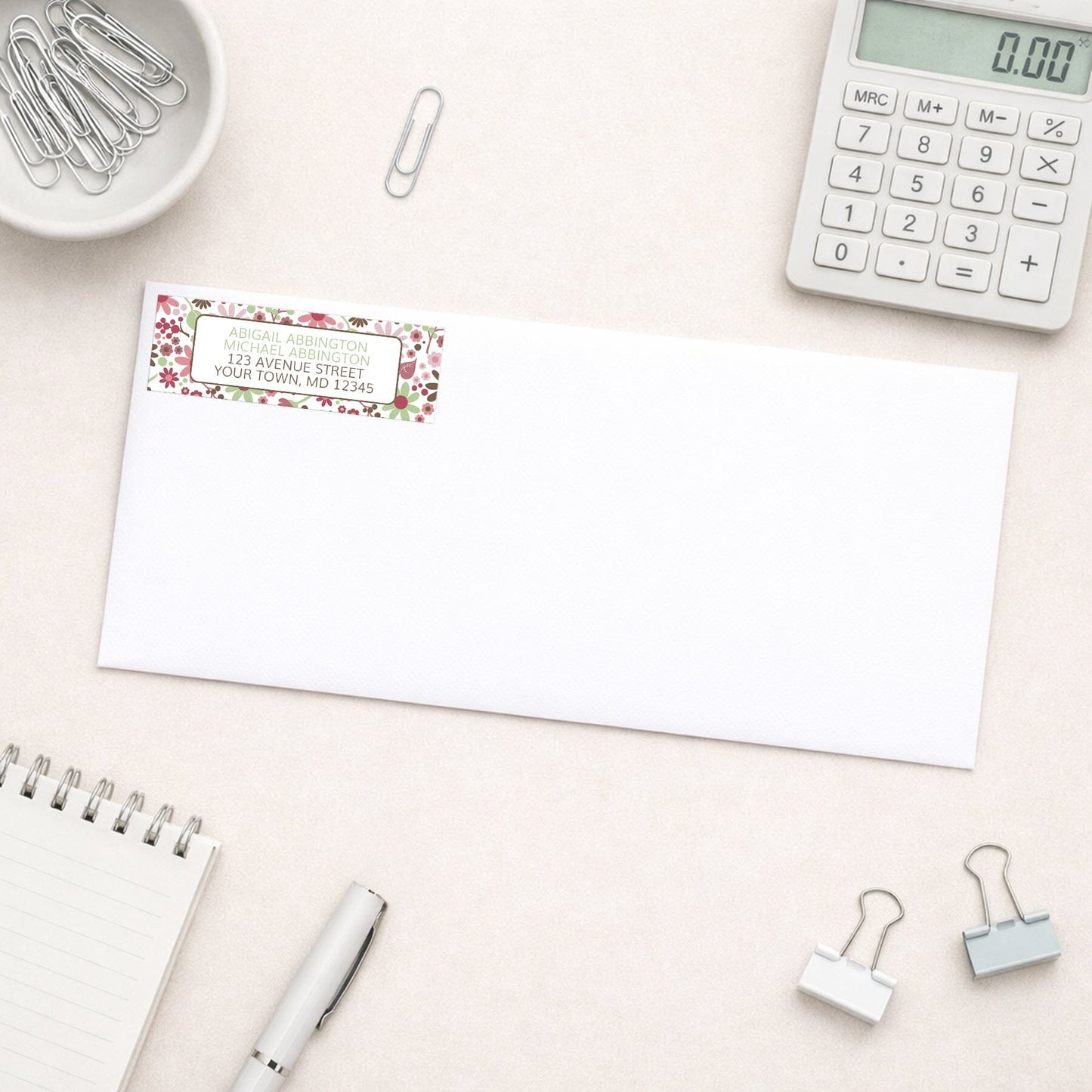 Berry Green Summer Flowers Address Label shown on a white envelope with everyday office supplies