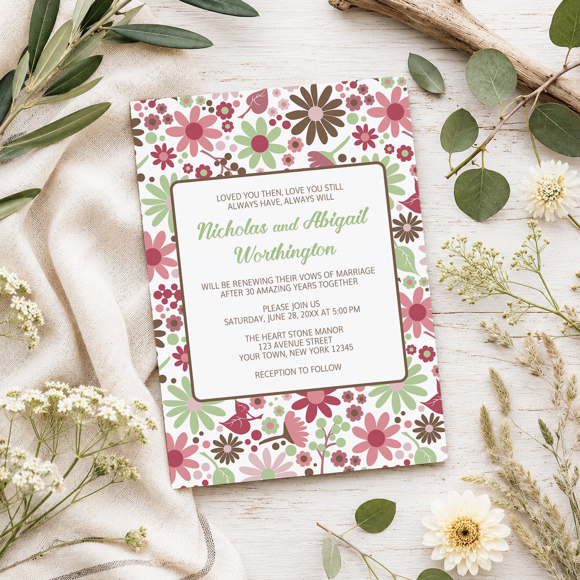 Berry Green Summer Flowers Vow Renewal Invitation shown on a light wooden surface with spring and summer plants.