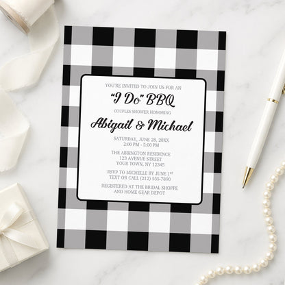 Black and White Buffalo Plaid I Do BBQ Couples Shower Invitation shown on a marble surface with a white gift box, ribbon, pen, and pearls.