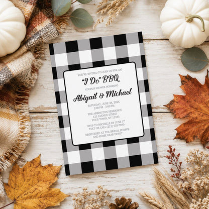 Black and White Buffalo Plaid I Do BBQ Couples Shower Invitation shown on a light wooden surface with fall leaves and autumn decor.