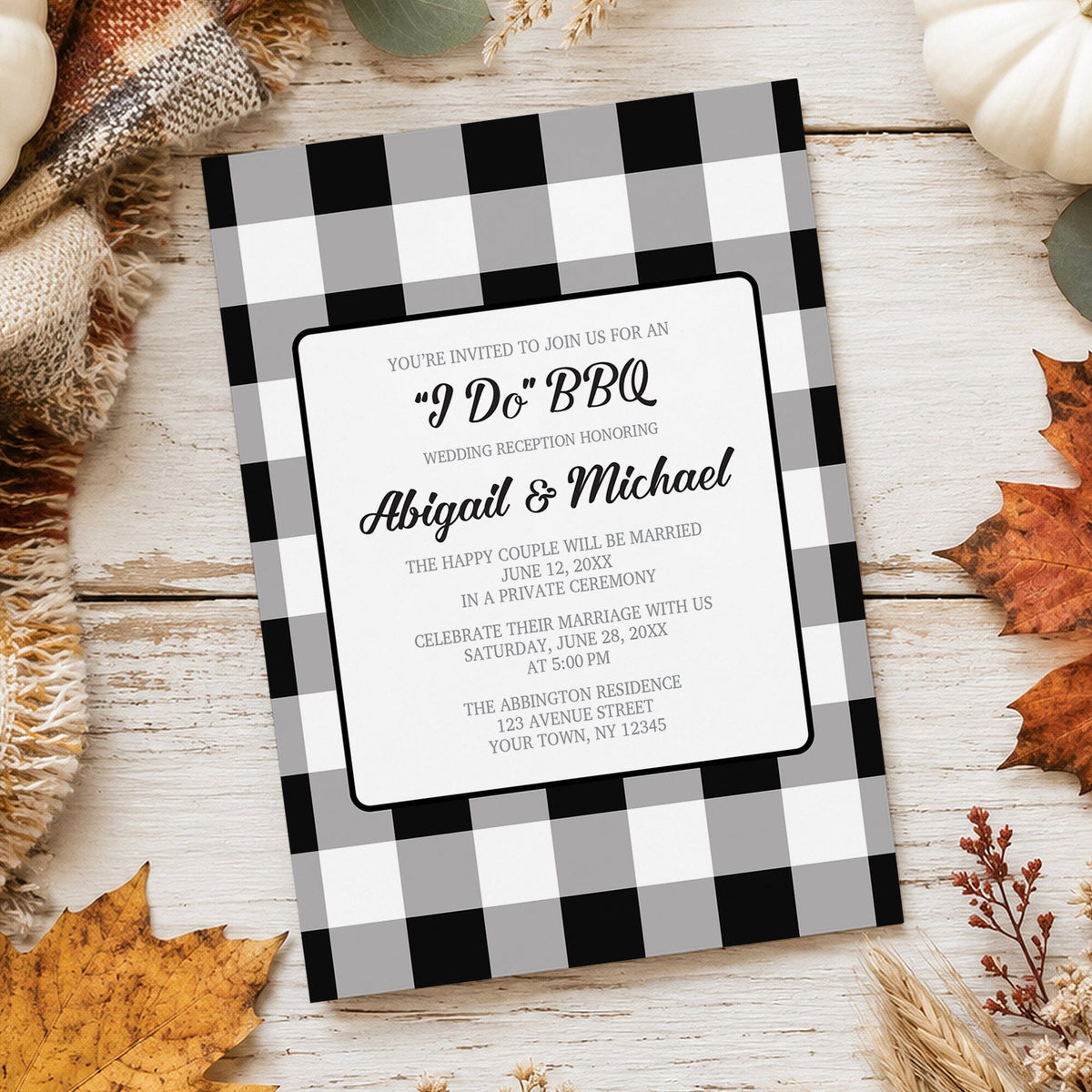 Black and white buffalo plaid I Do BBQ reception only wedding invitation with gray checks, black script lettering, and centered white wording panel, styled on a whitewashed wood surface with autumn leaves, burlap, and pumpkins around it.