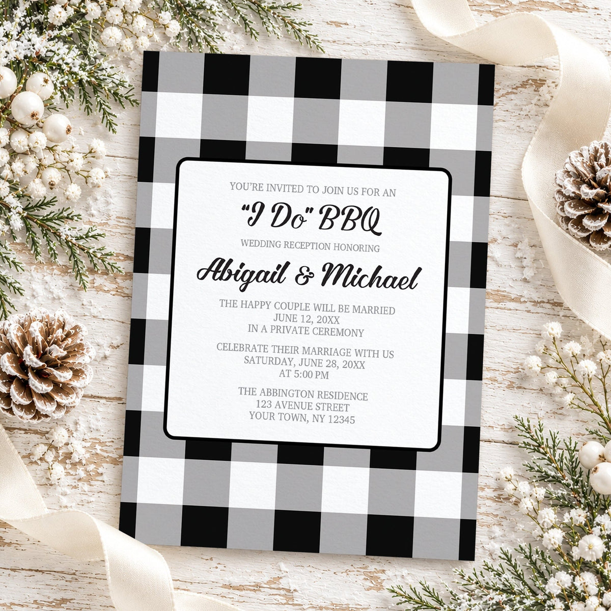 Black and white buffalo plaid I Do BBQ reception only wedding invitation with gray checks, black script lettering, and centered white wording panel, styled in a flat-lay with pinecones, white berries, winter greenery, and a cream ribbon on a whitewashed wood background.