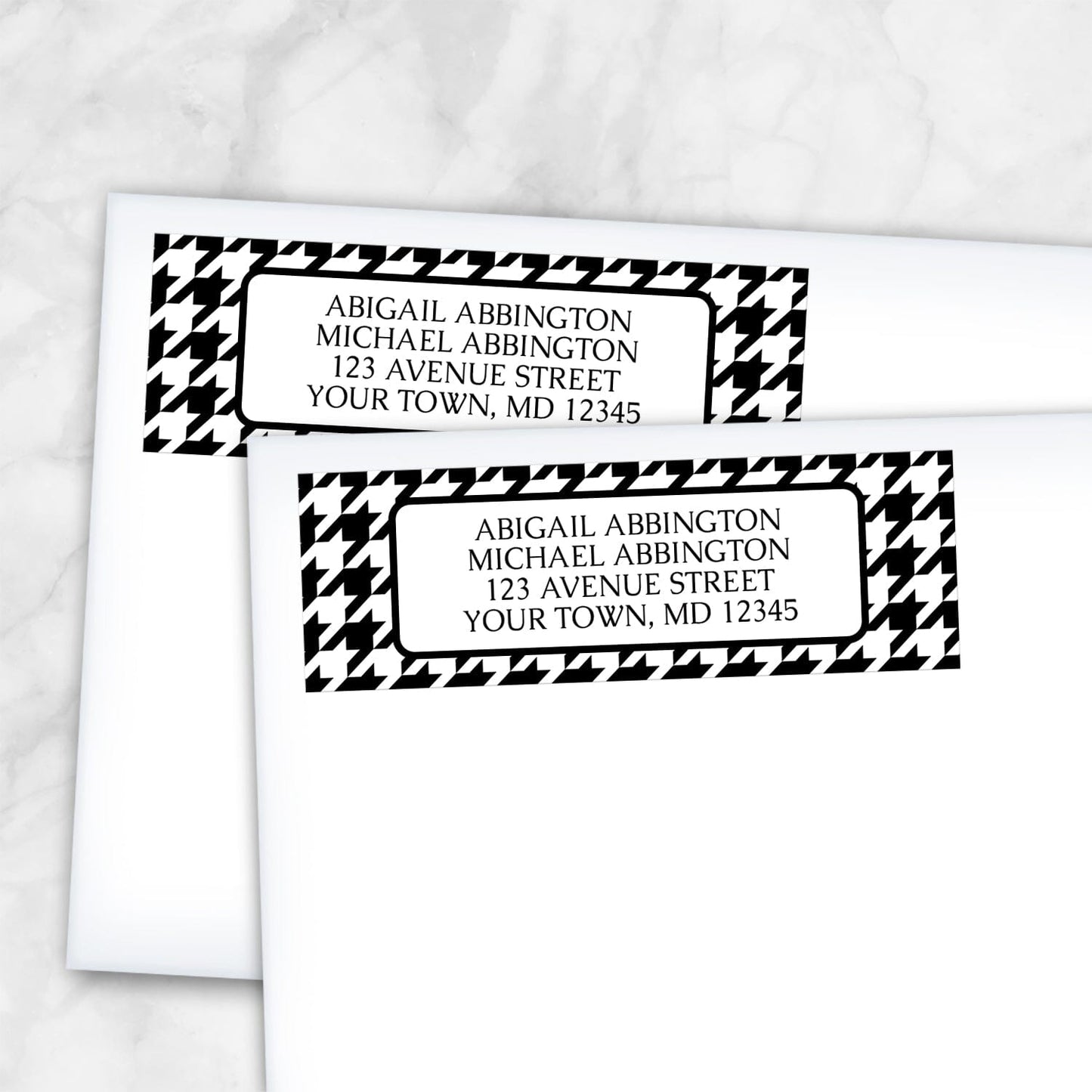 Two personalized Black and White Houndstooth Address Labels on white envelopes on a marble surface.