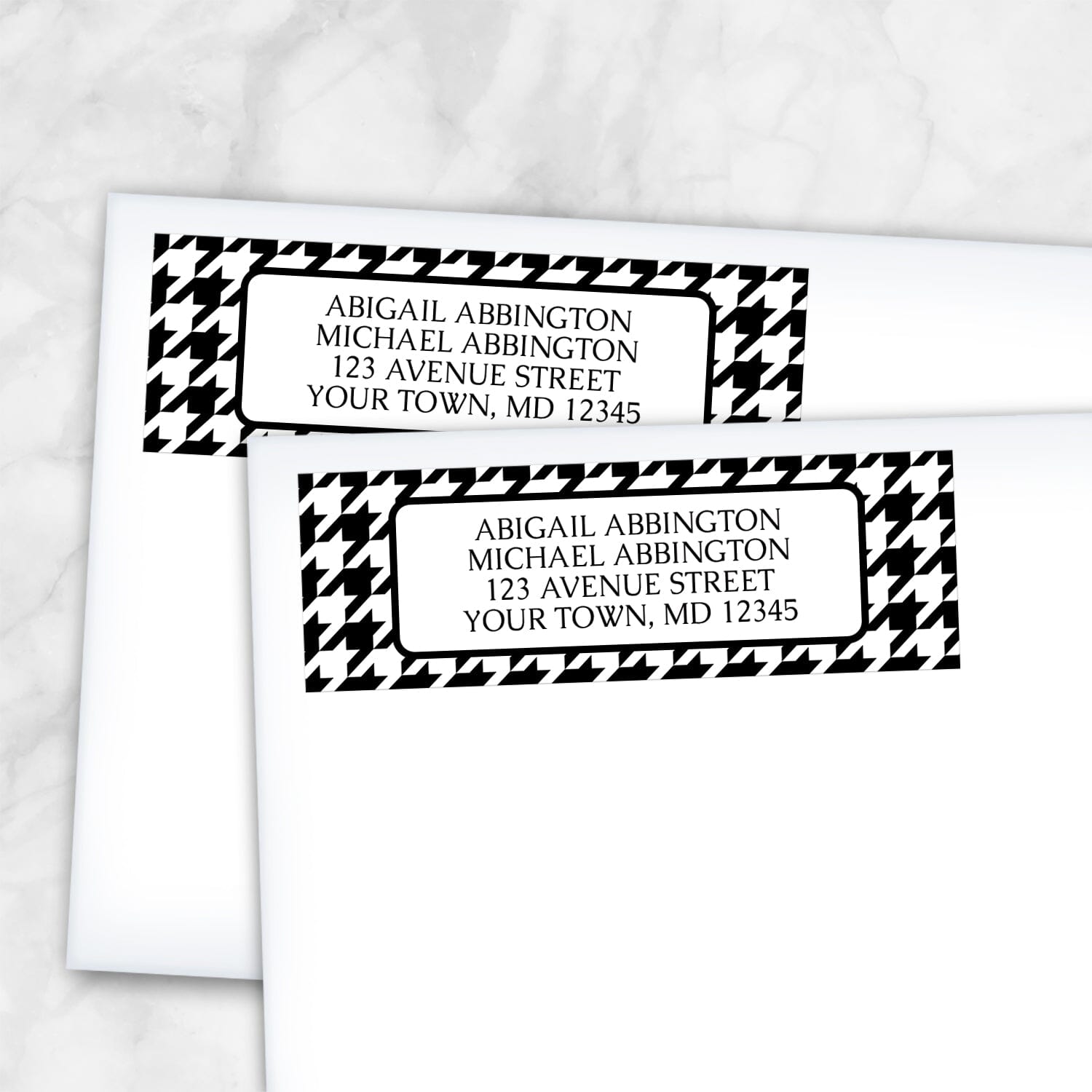Two personalized Black and White Houndstooth Address Labels on white envelopes on a marble surface.