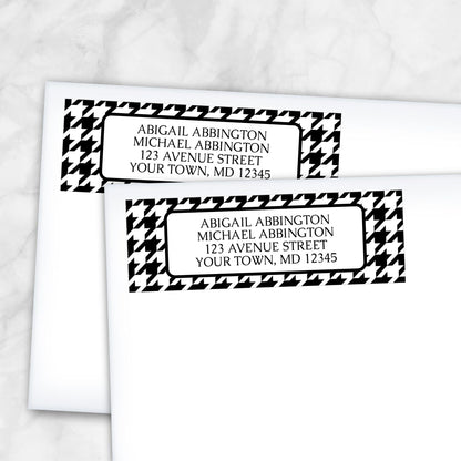 Two personalized Black and White Houndstooth Address Labels on white envelopes on a marble surface.
