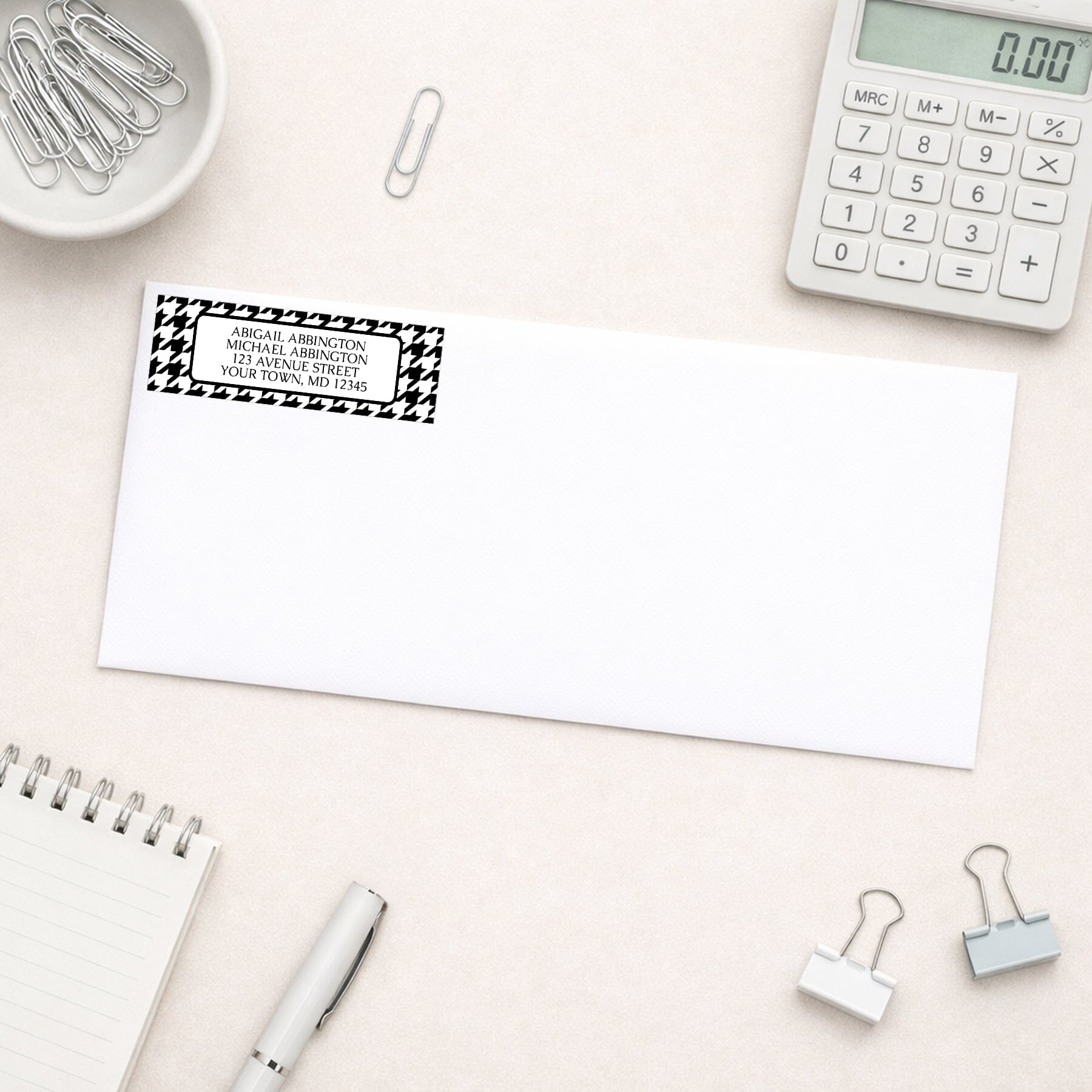 Black and White Houndstooth Address Label on a white envelope on a desk with office supplies.