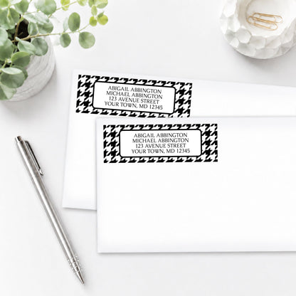 Black and White Houndstooth Address Labels on two white envelopes on a white surface with a plant and a pen.