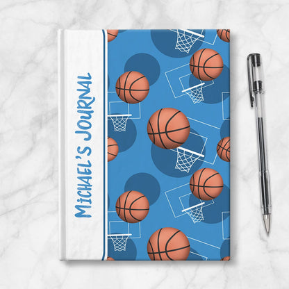 Personalized Blue Basketball Journal at Artistically Invited. Image shows the book on a countertop next to a pen.