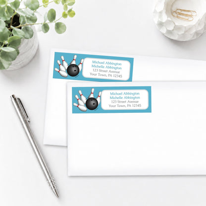 Blue Bowling Address Labels on envelopes with a pen and plant in the background