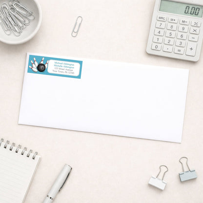 Blue Bowling Return Address Label shown on a white envelope with everyday office supplies