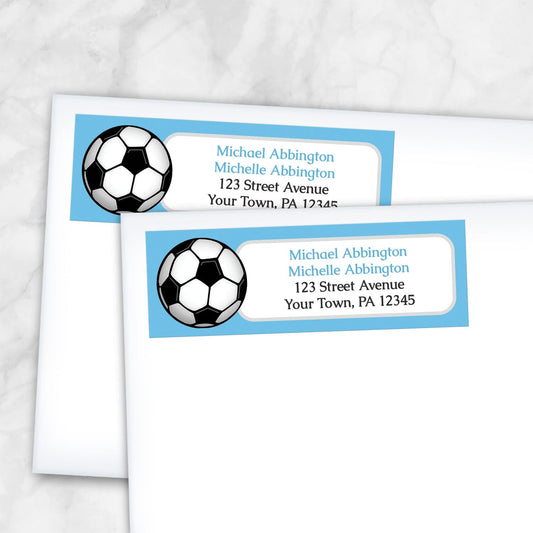 2 Blue Soccer Ball Return Address Labels shown on white envelopes on a marble surface
