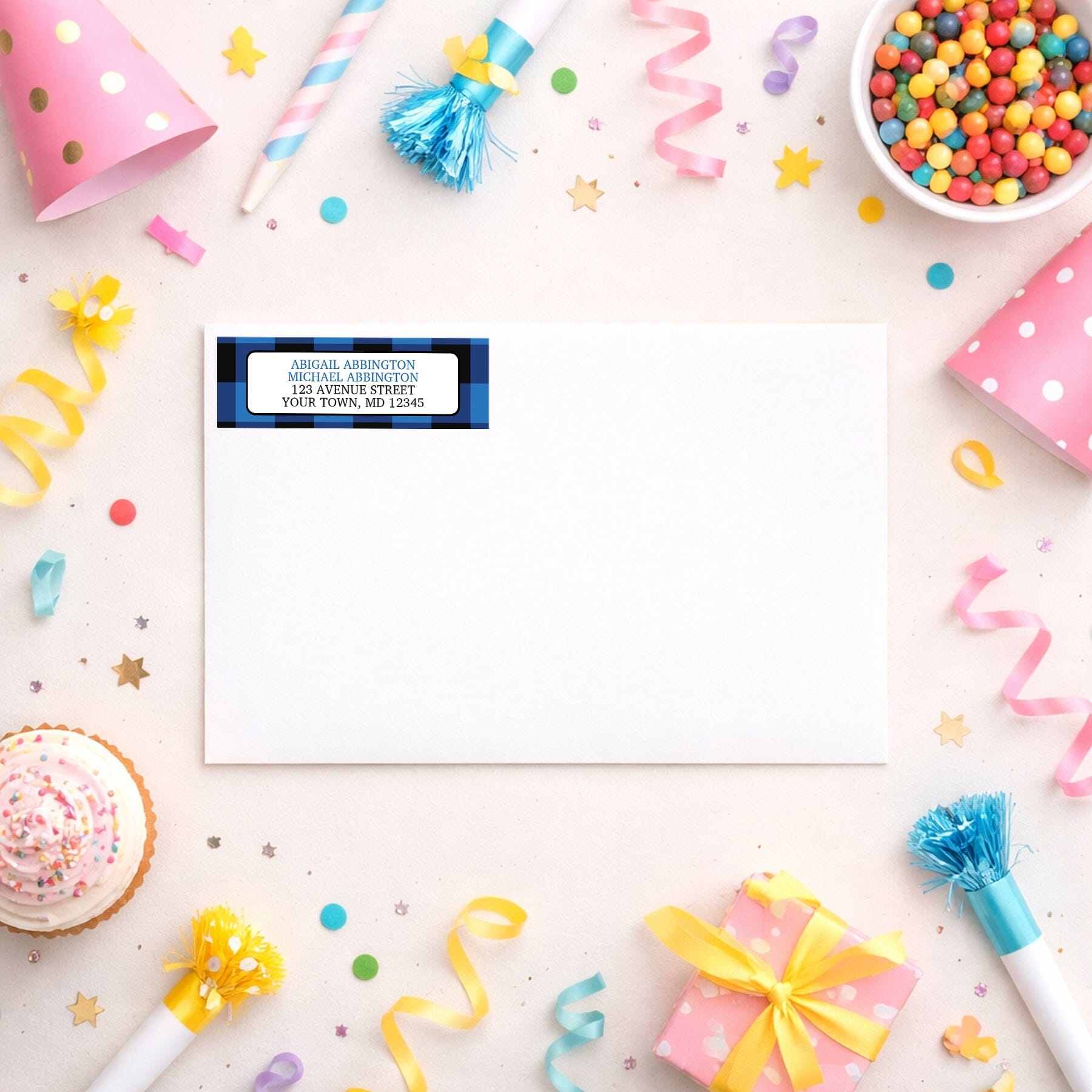Blue and Black Buffalo Plaid Address Label shown on a white envelope with party supplies