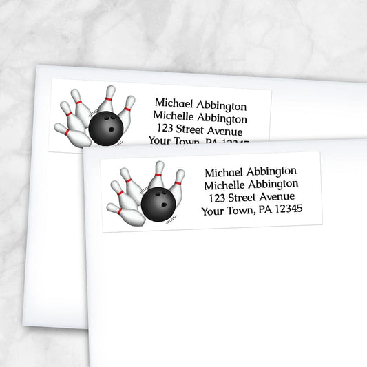Bowling Ball and Pins Address Labels at Artistically Invited. Custom return address labels designed with a bowling illustration on the left side, featuring a bowling ball striking pins. Your personalized return address is custom printed in black to the right of the bowling design over a white background. Image shows two labels on envelopes.