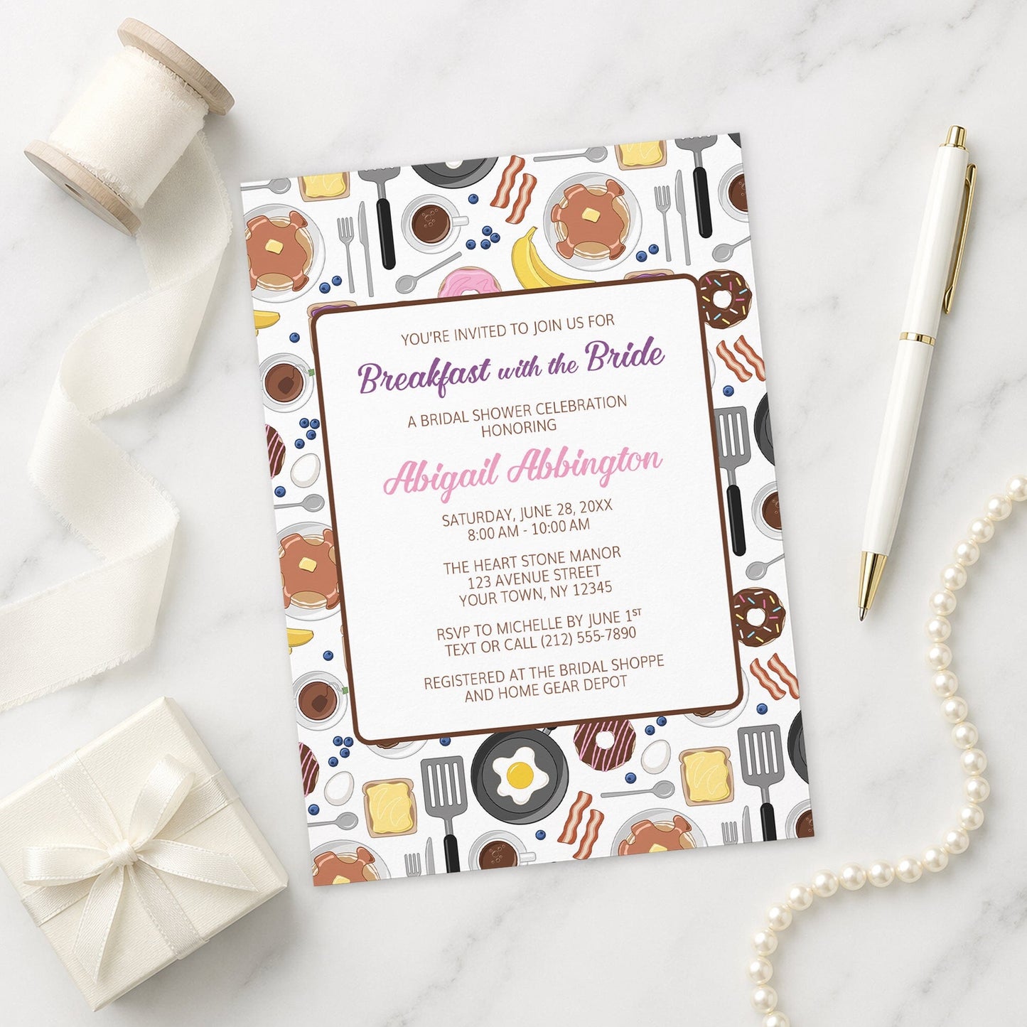 Breakfast with the Bride Bridal Shower Invitation on a marble surface with decorative items.