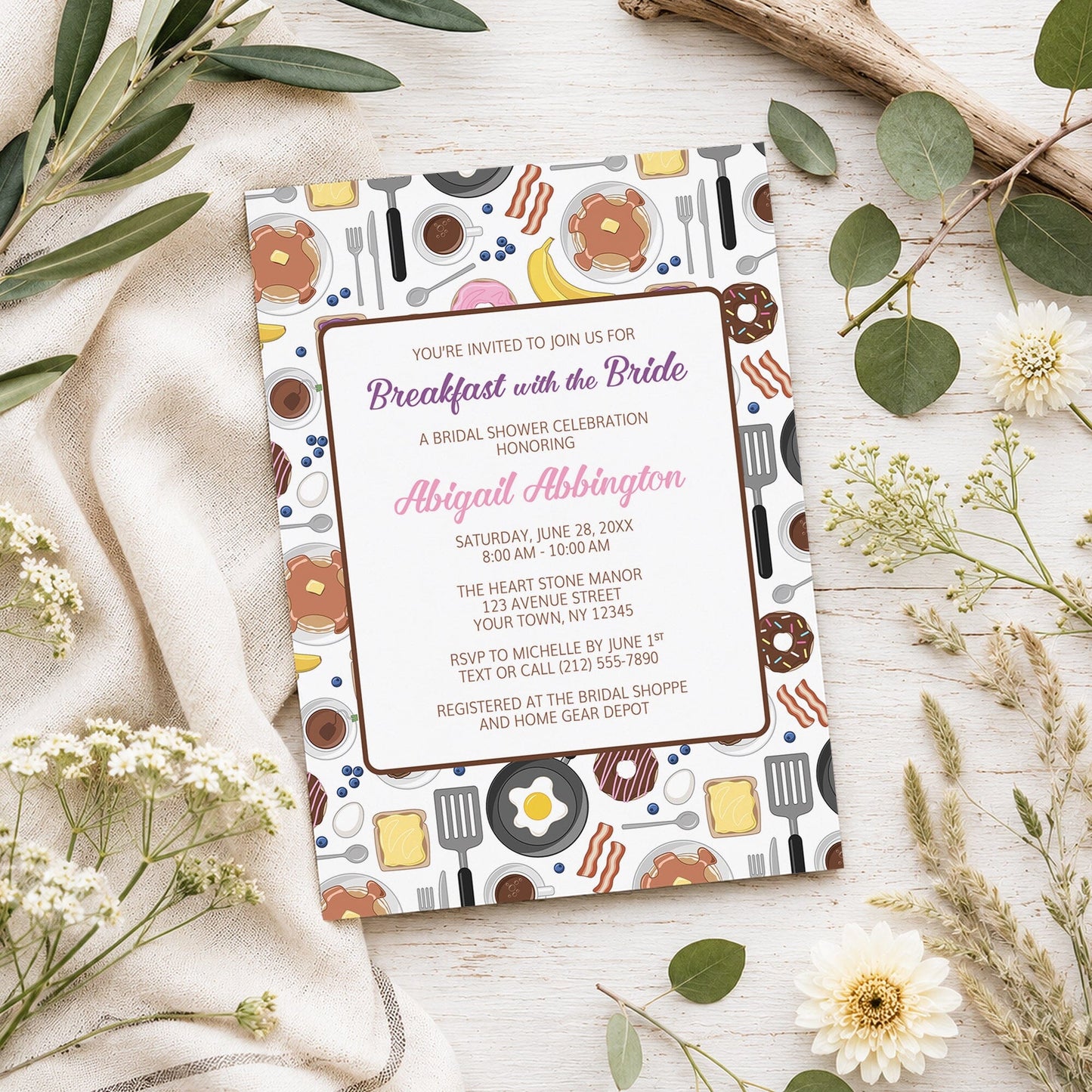 Breakfast with the Bride Bridal Shower Invitation shown on a light wooden surface with spring and summer plants.
