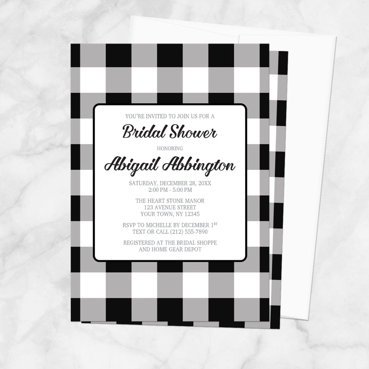 Bridal shower invitation with black and white checkered border, with a white envelope, on a marble background
