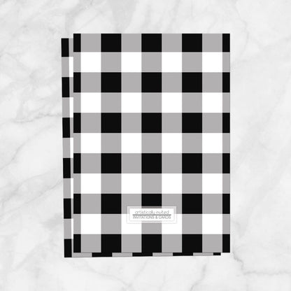 Backside of the printed invitation upgrade with a black and white checkered pattern, shown over a marble countertop