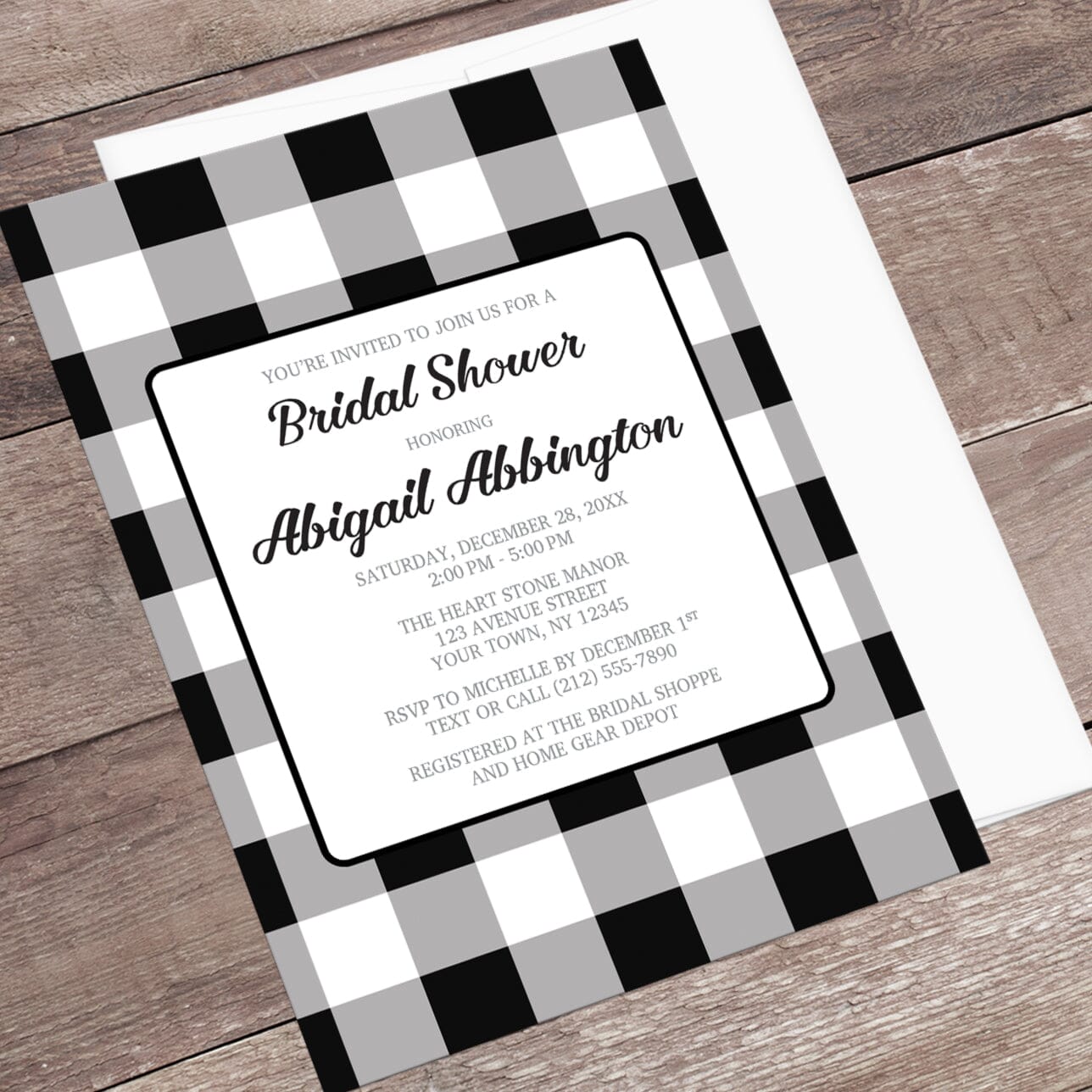 Bridal shower invitation with black and white checkered border on a wooden surface
