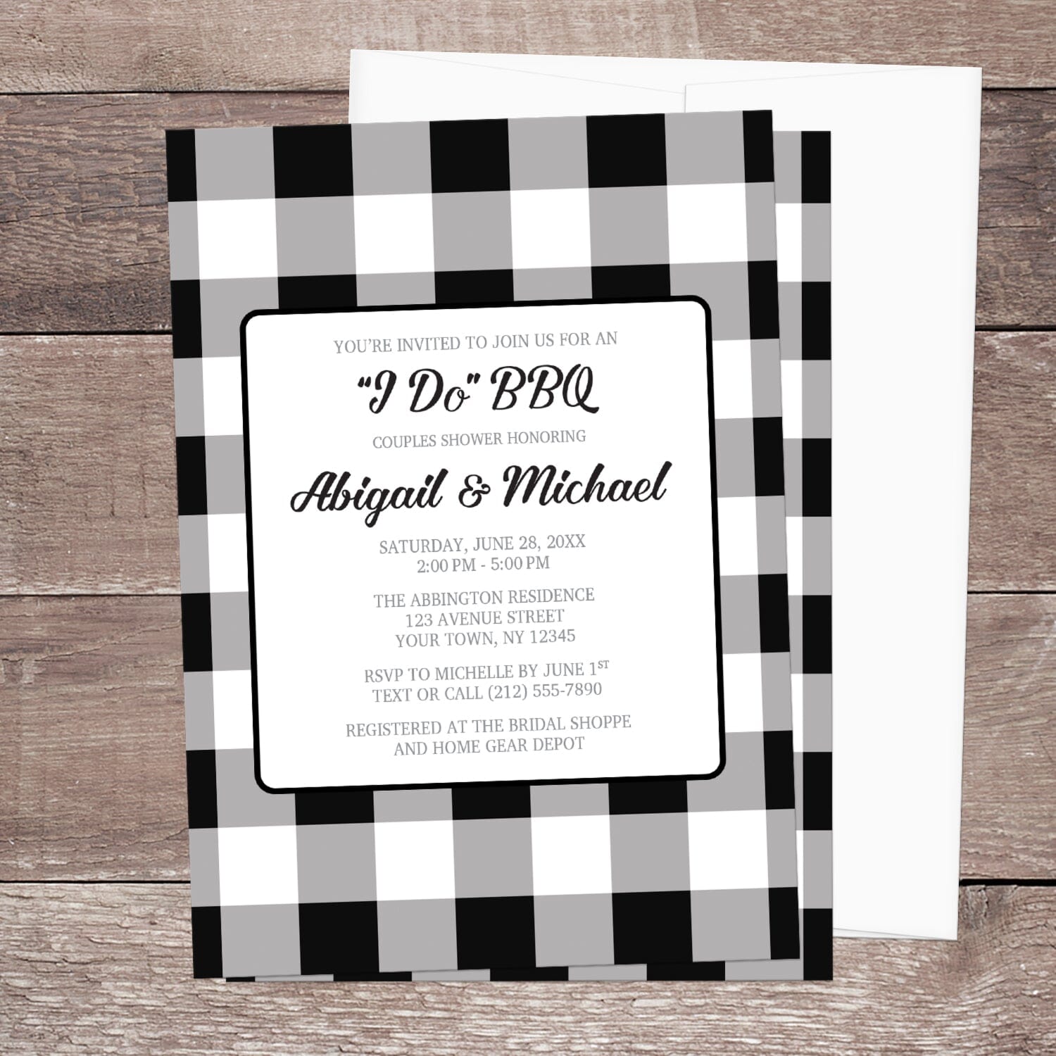 Black and White Buffalo Plaid I Do BBQ Couples Shower Invitation shown on a brown wood surface with a white envelope.