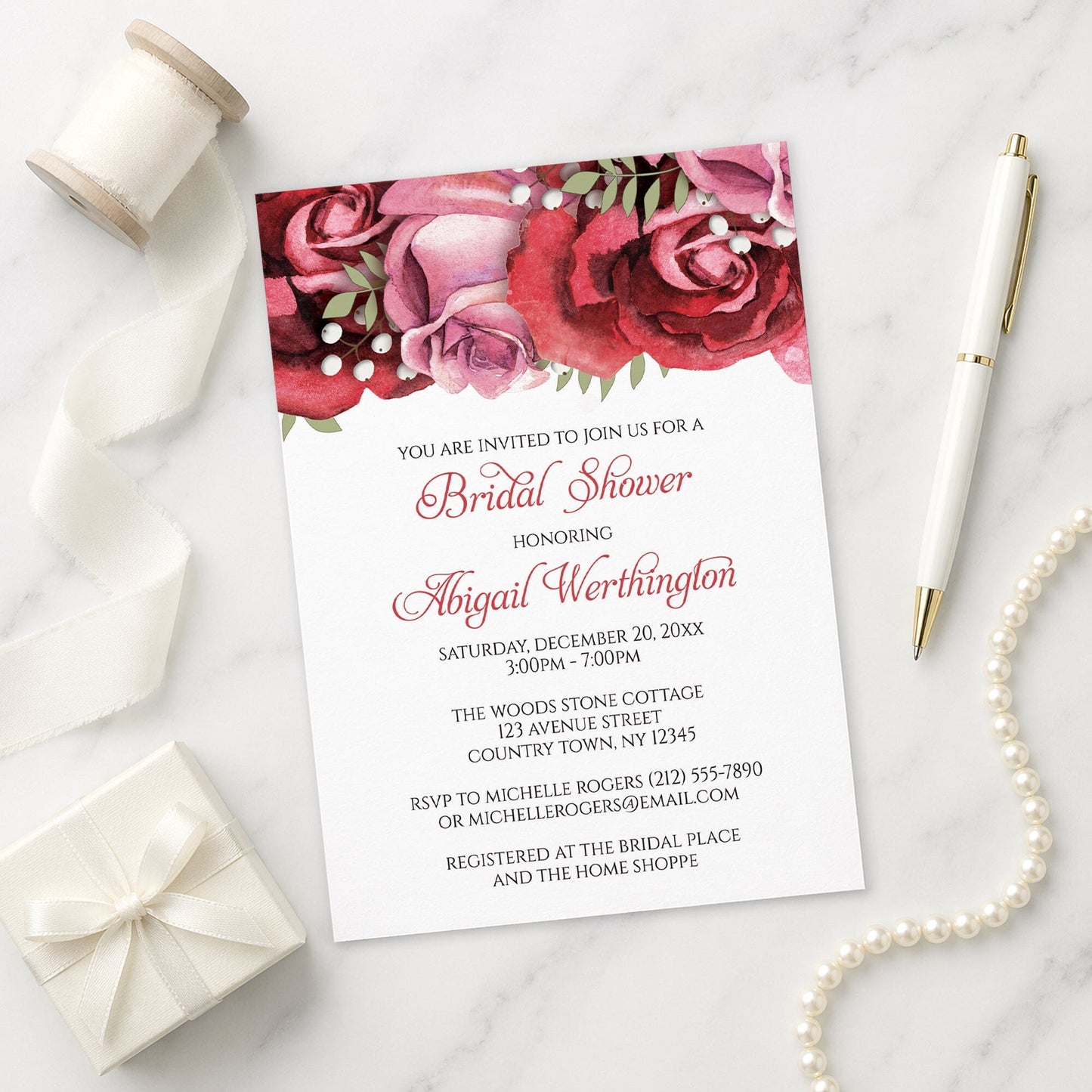 Burgundy Red Pink Rose Bridal Shower Invitation on a marble surface with a white gift box, pen, ribbon, and pearls.