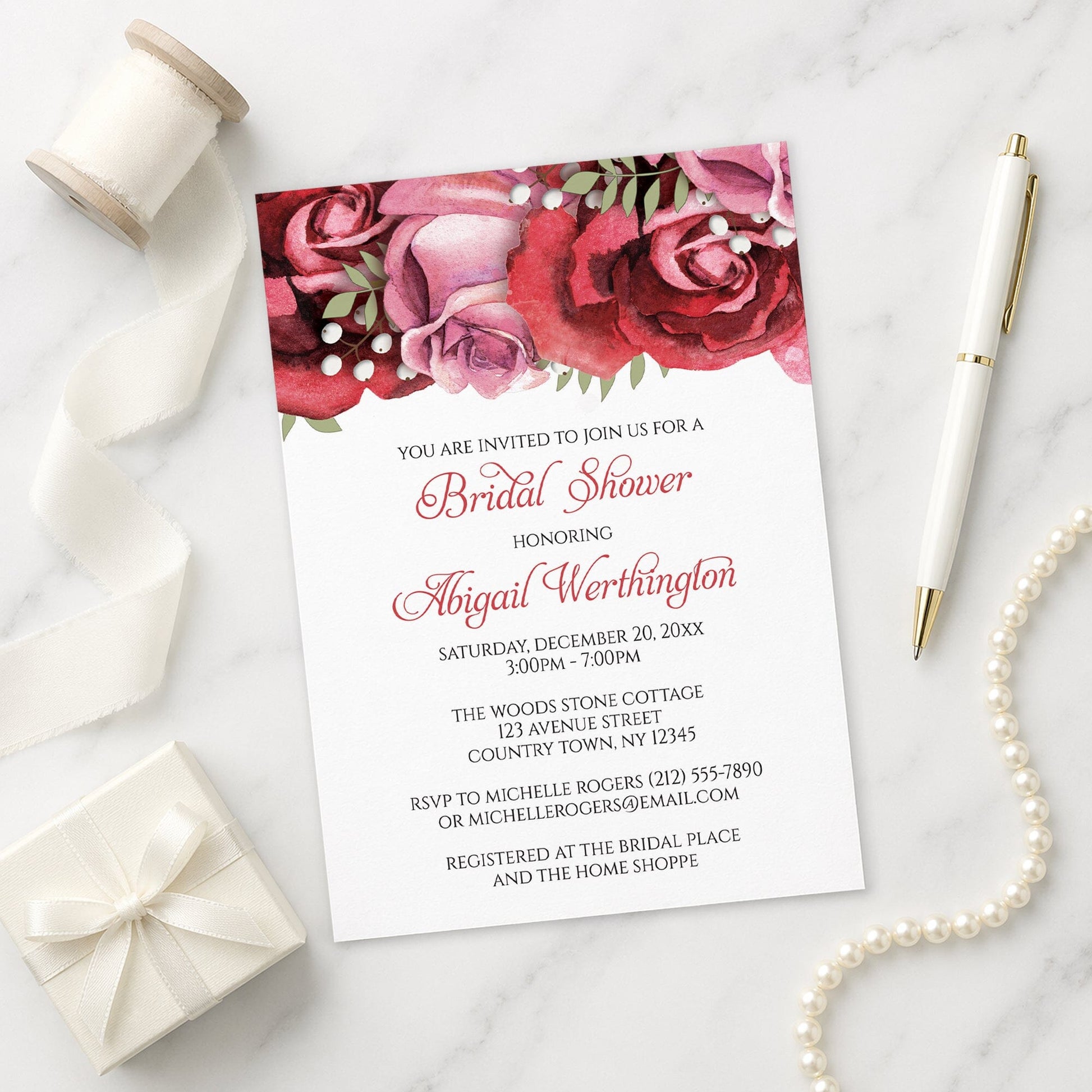 Burgundy Red Pink Rose Bridal Shower Invitation on a marble surface with a white gift box, pen, ribbon, and pearls.