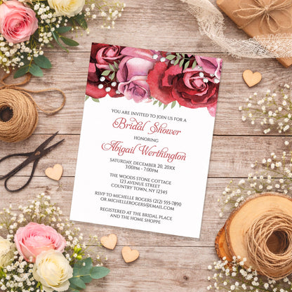 Burgundy Red Pink Rose Bridal Shower Invitation on a wooden surface with spring and summer flowers and twine.