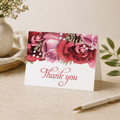 Burgundy Red Pink Rose Thank You Card on a desk with vase, plants, and a pen.