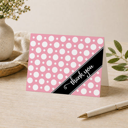 Cafe Pink Polka Dot Thank You Card shown on a desk with a vase, plants, and a pen.