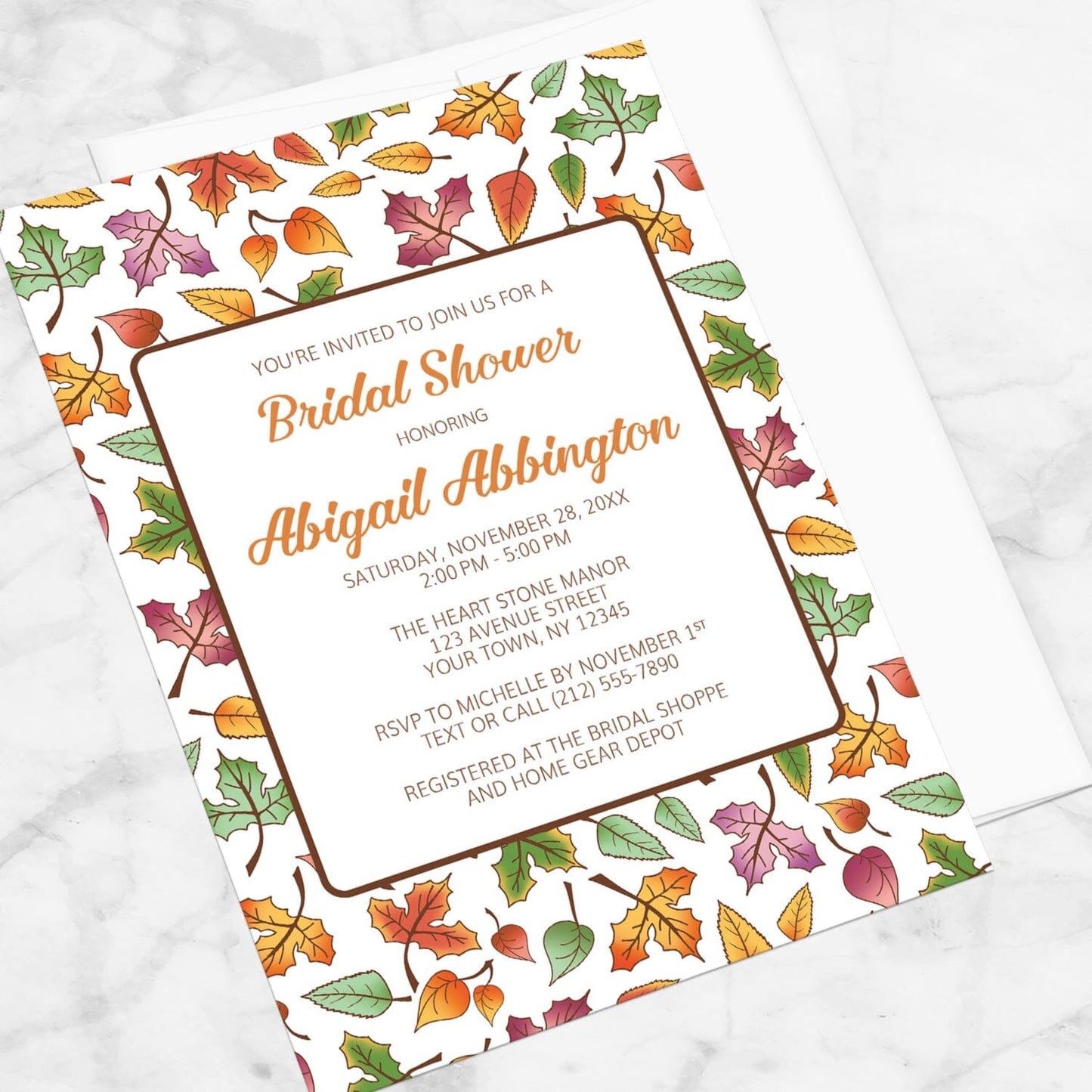 Changing Leaves Fall Bridal Shower Invitation shown at an angle on a marble surface.