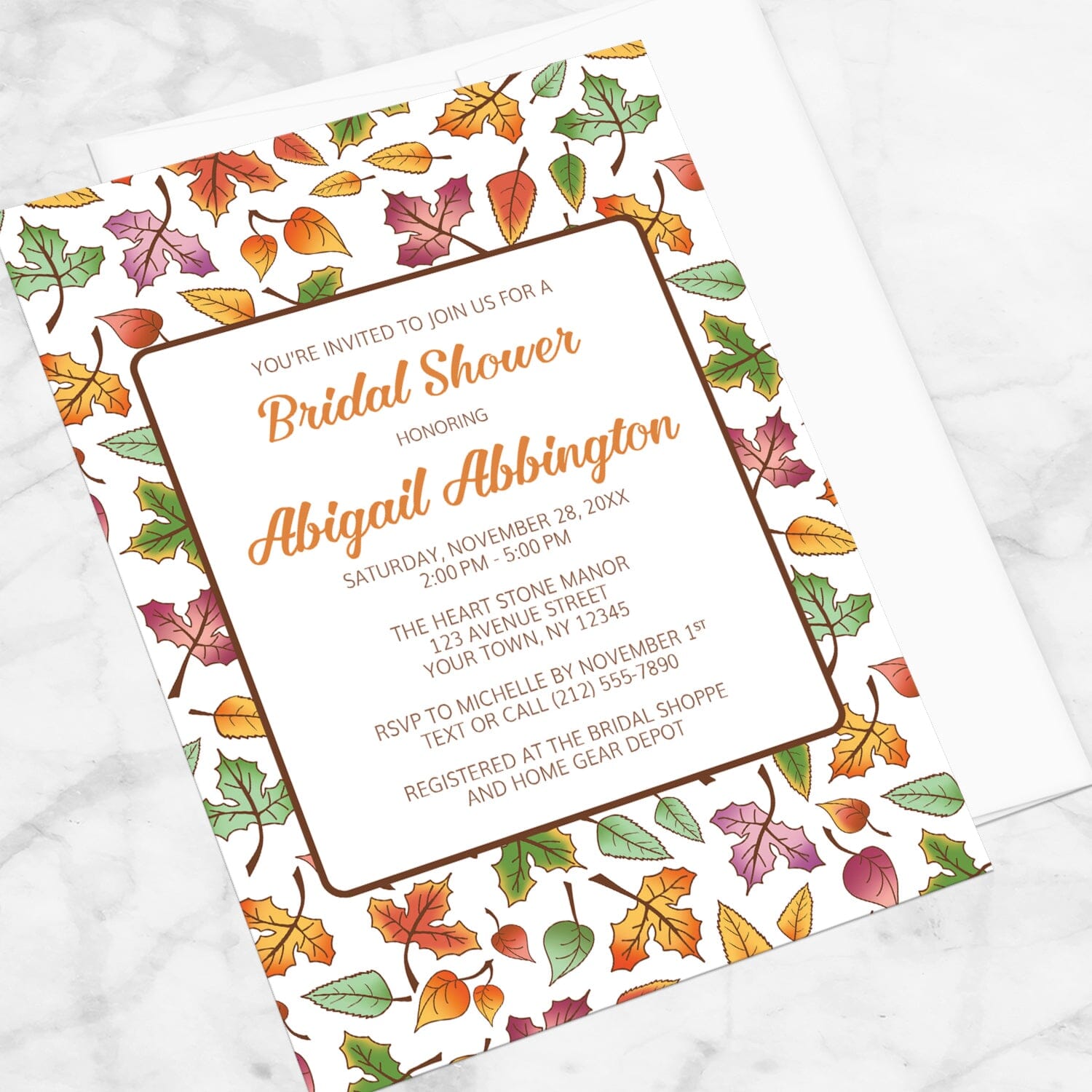 Changing Leaves Fall Bridal Shower Invitation shown at an angle on a marble surface.