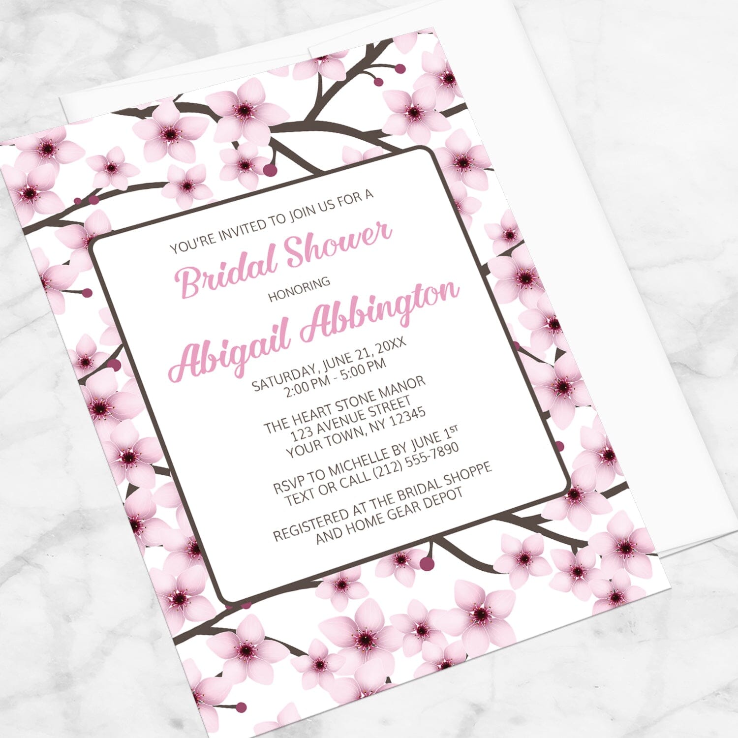 Cherry Blossom Bridal Shower Invitation shown at an angle on a marble surface.