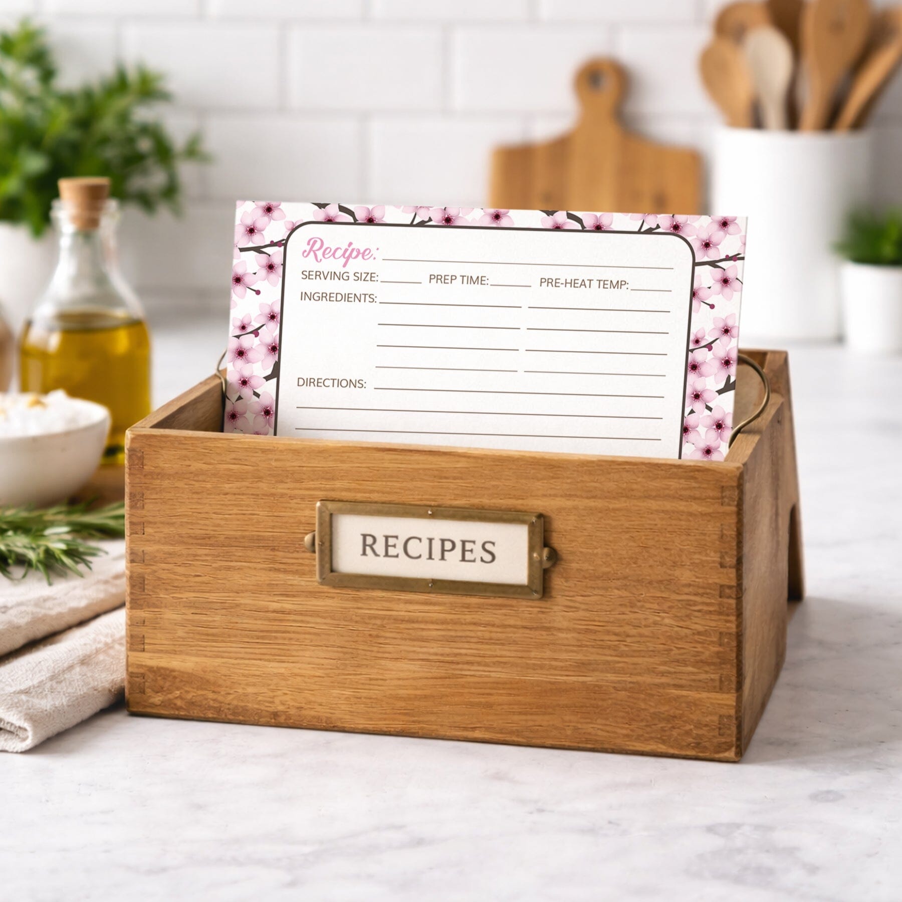 Wooden recipe box with a Cherry Blossom Recipe Card on a kitchen counter.