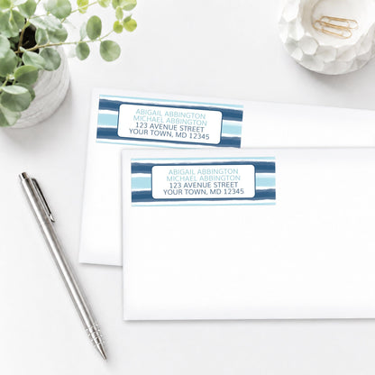 Coastal Paint Brush Strokes Address Labels shown on white envelopes on a white surface with a plant and a pen.